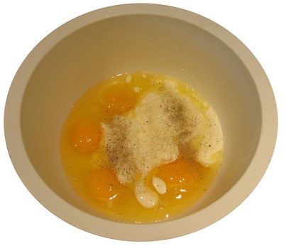 Saladier avec les œufs et la crème.