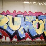 Photo of the word Rumor tagged on a wall.